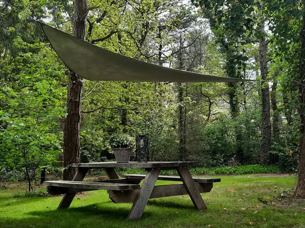 Tuin met picknicktafel en zonnescherm