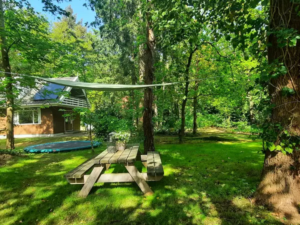 Tuin met picknicktafel en schaduwzeil